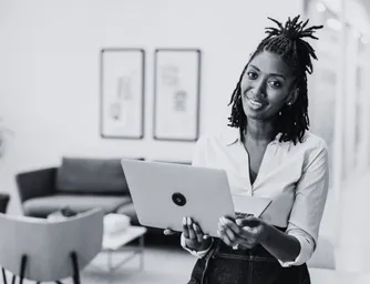 A smiling woman holding a laptop